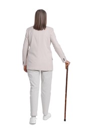 Photo of Senior woman with walking cane on white background, back view