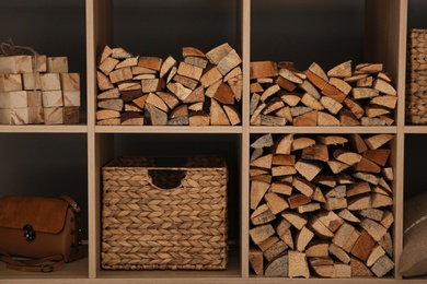 Photo of Shelving unit with stacked firewood, closeup. Idea for interior design