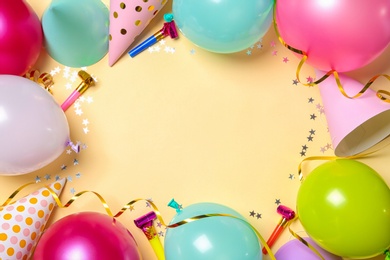 Photo of Frame made of balloons and party accessories on color background, top view with space for text