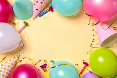 Frame made of balloons and party accessories on color background, top view with space for text