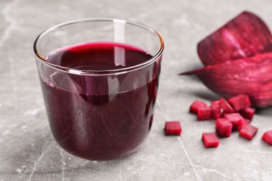 Glass with fresh healthy beet juice on table