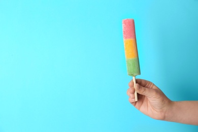 Woman holding delicious ice cream against color background, space for text