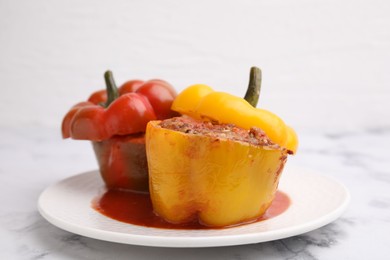 Photo of Delicious stuffed bell peppers served on white marble table