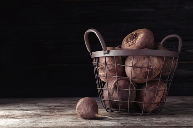 Photo of Basket with whole fresh beets on wooden table