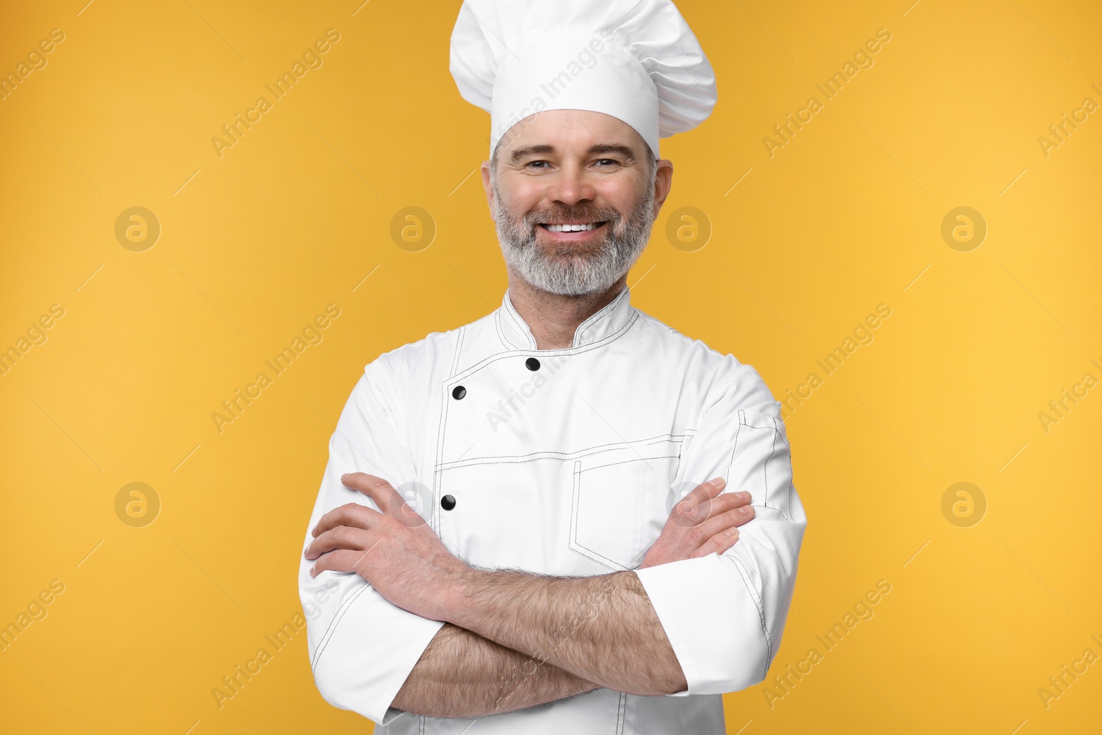 Photo of Happy chef in uniform on orange background