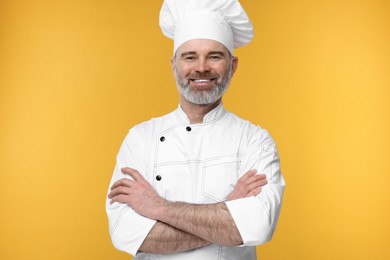 Happy chef in uniform on orange background