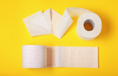 Photo of Rolls of toilet paper on color background, top view
