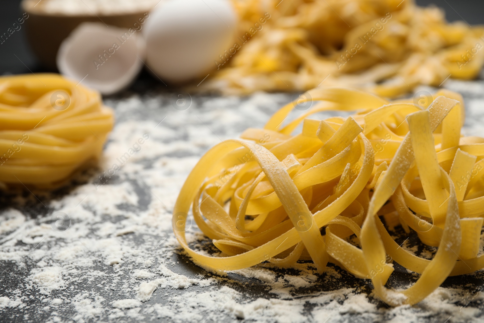 Photo of Tagliatelle pasta on grey table, closeup view