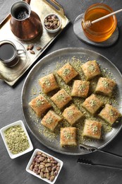 Photo of Delicious fresh baklava with chopped nuts served on grey table, flat lay. Eastern sweets