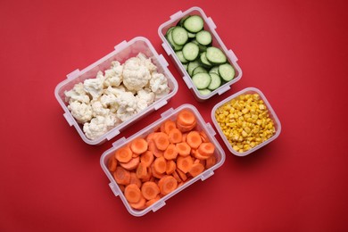 Photo of Plastic containers with different fresh products on red background, flat lay