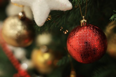 Beautiful red bauble hanging on Christmas tree, closeup. Space for text