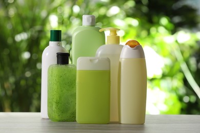Photo of Different blank shower gel bottles on wooden table