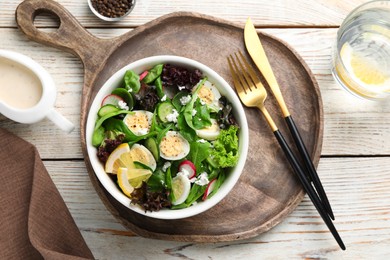 Photo of Delicious salad with boiled eggs, vegetables and lemon served on white wooden table, flat lay