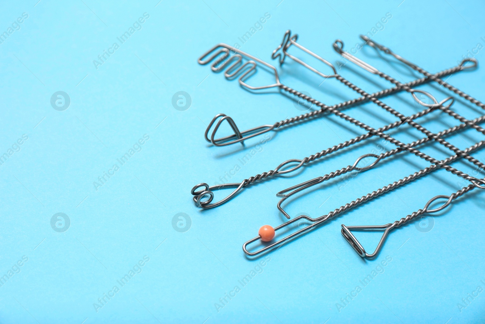 Photo of Set of logopedic probes for speech therapy on light blue background