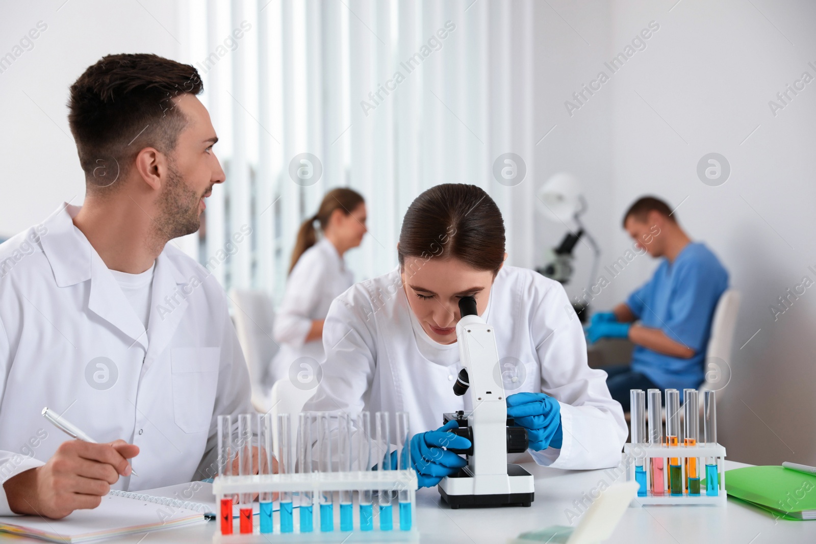 Photo of Medical students with microscope in modern laboratory