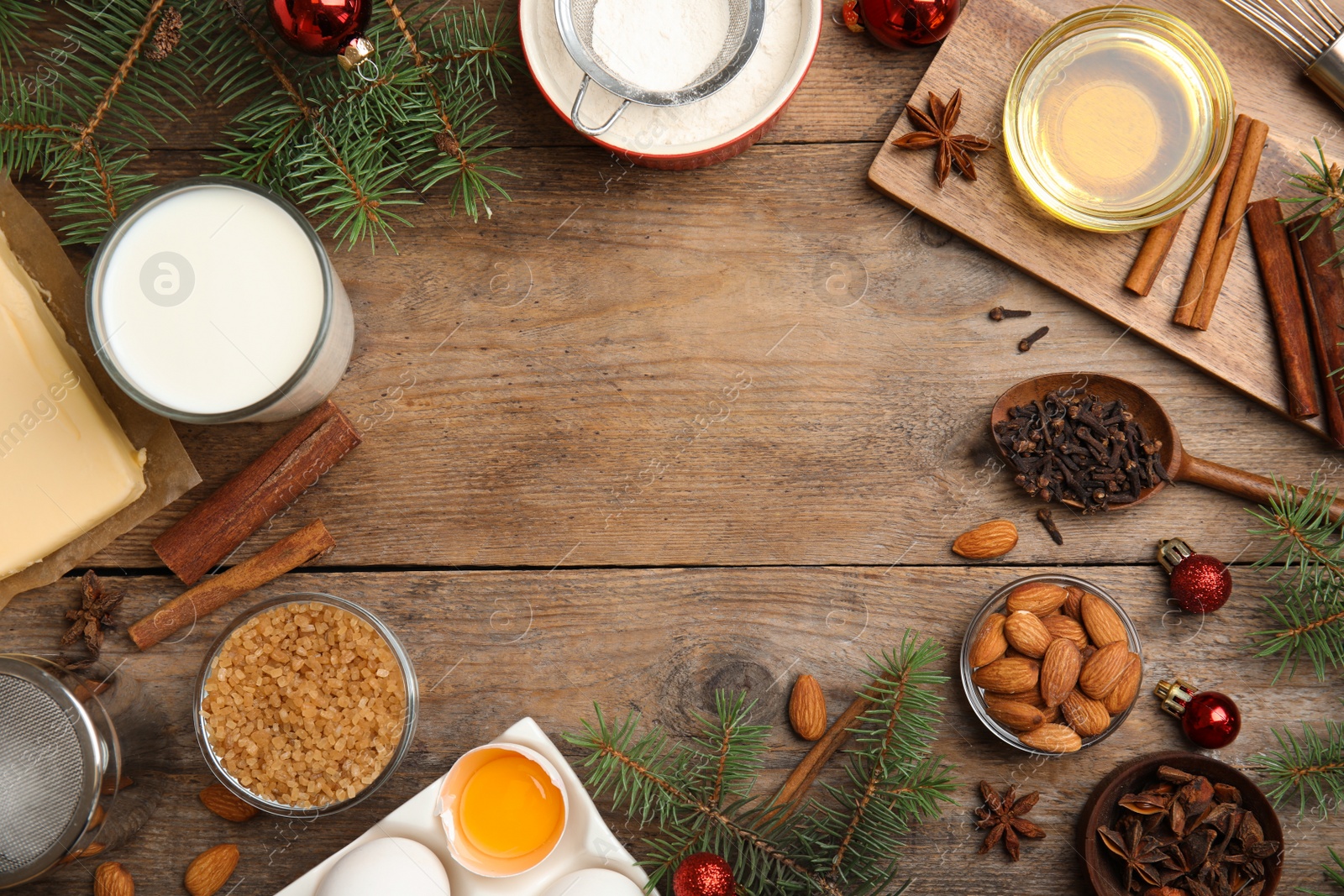 Photo of Flat lay composition with ingredients for traditional Christmas cake on wooden table. Space for text