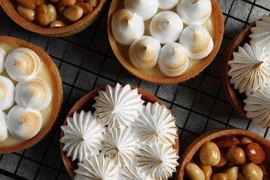 Photo of Many different tartlets on light grey table, flat lay. Tasty dessert