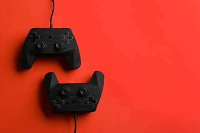 Photo of Modern video game controllers on color background, top view with space for text