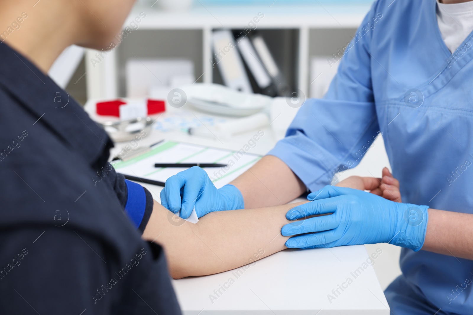 Photo of Laboratory testing. Doctor taking blood sample from patient at white table in hospital, closeup