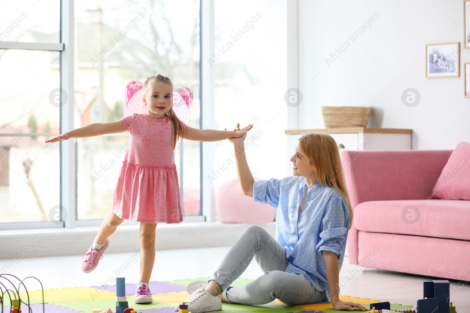 Photo of Mother playing with her child at home