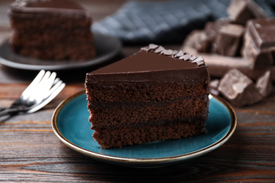 Piece of delicious chocolate cake on wooden table