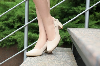 Photo of Woman in stylish shoes on stairs outdoors, closeup