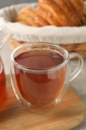 Photo of Aromatic tea in glass cup on table, closeup