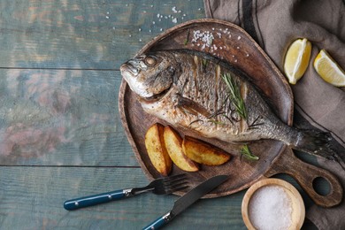 Photo of Seafood. Delicious baked fish served on wooden rustic table, flat lay with space for text