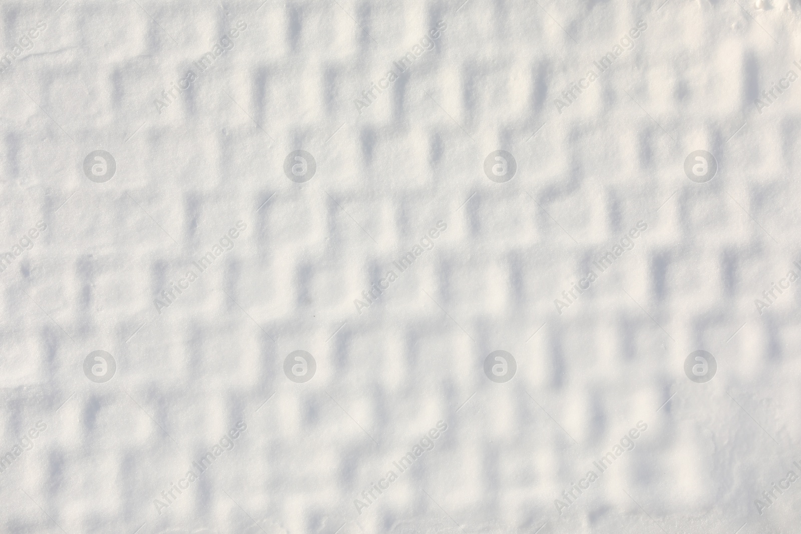 Photo of White snow with pattern as background, top view. Winter season