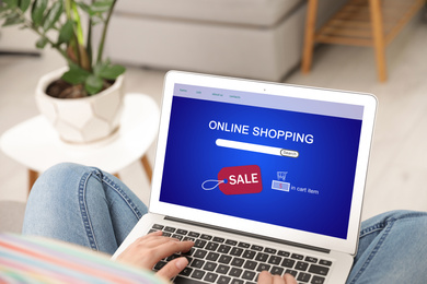 Image of Woman using laptop for online shopping indoors, closeup