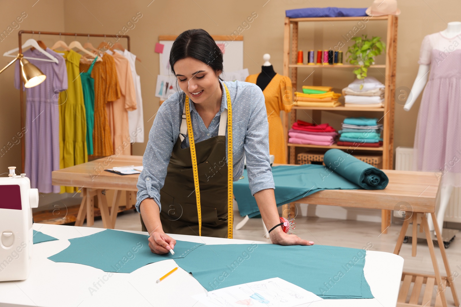 Photo of Dressmaker marking fabric with chalk in workshop