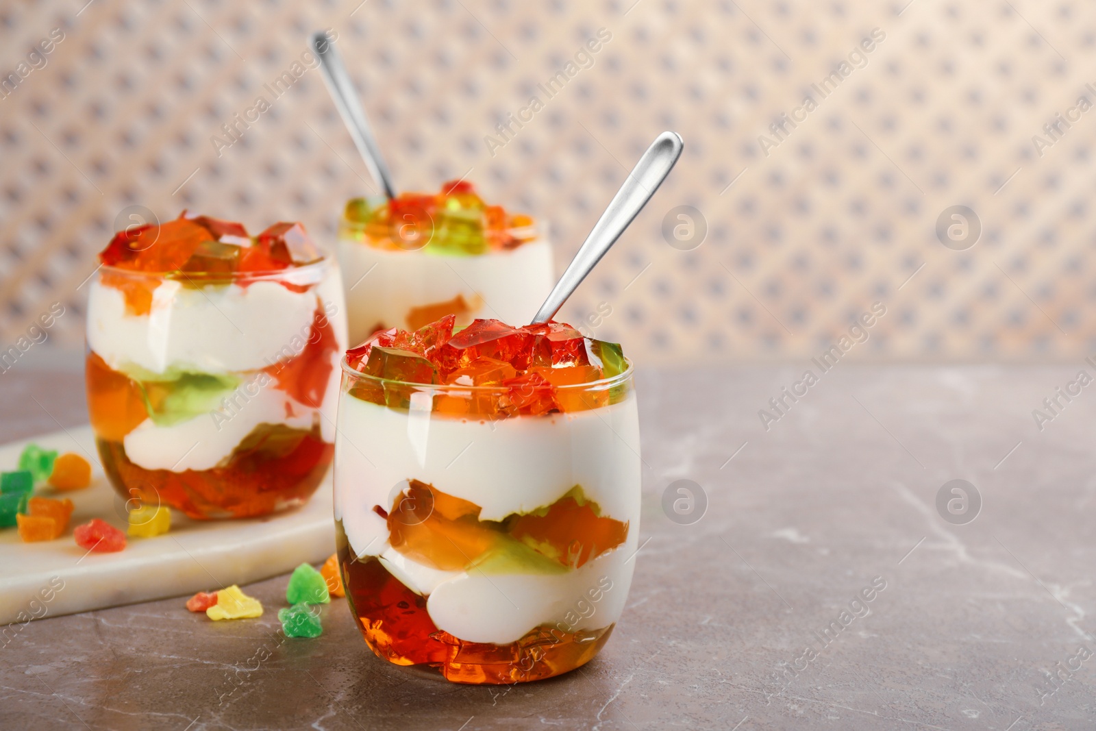 Photo of Delicious broken glass jelly dessert on table, space for text