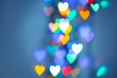 Photo of Blurred view of colorful heart shaped lights on light blue background
