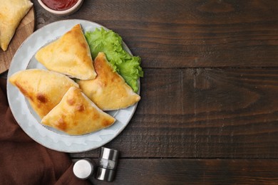 Delicious samosas and lettuce on wooden table, flat lay. Space for text