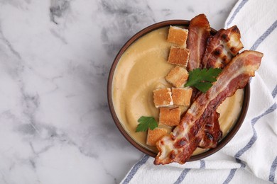 Photo of Delicious lentil soup with bacon and parsley in bowl on light marble table, top view. Space for text