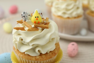 Photo of Tasty Easter cupcake with vanilla cream on table, closeup