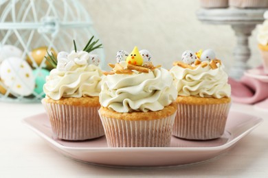 Photo of Tasty Easter cupcakes with vanilla cream on light wooden table