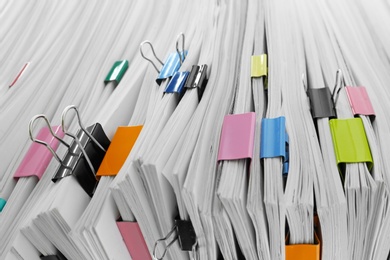 Photo of Pile of documents with colorful binder clips