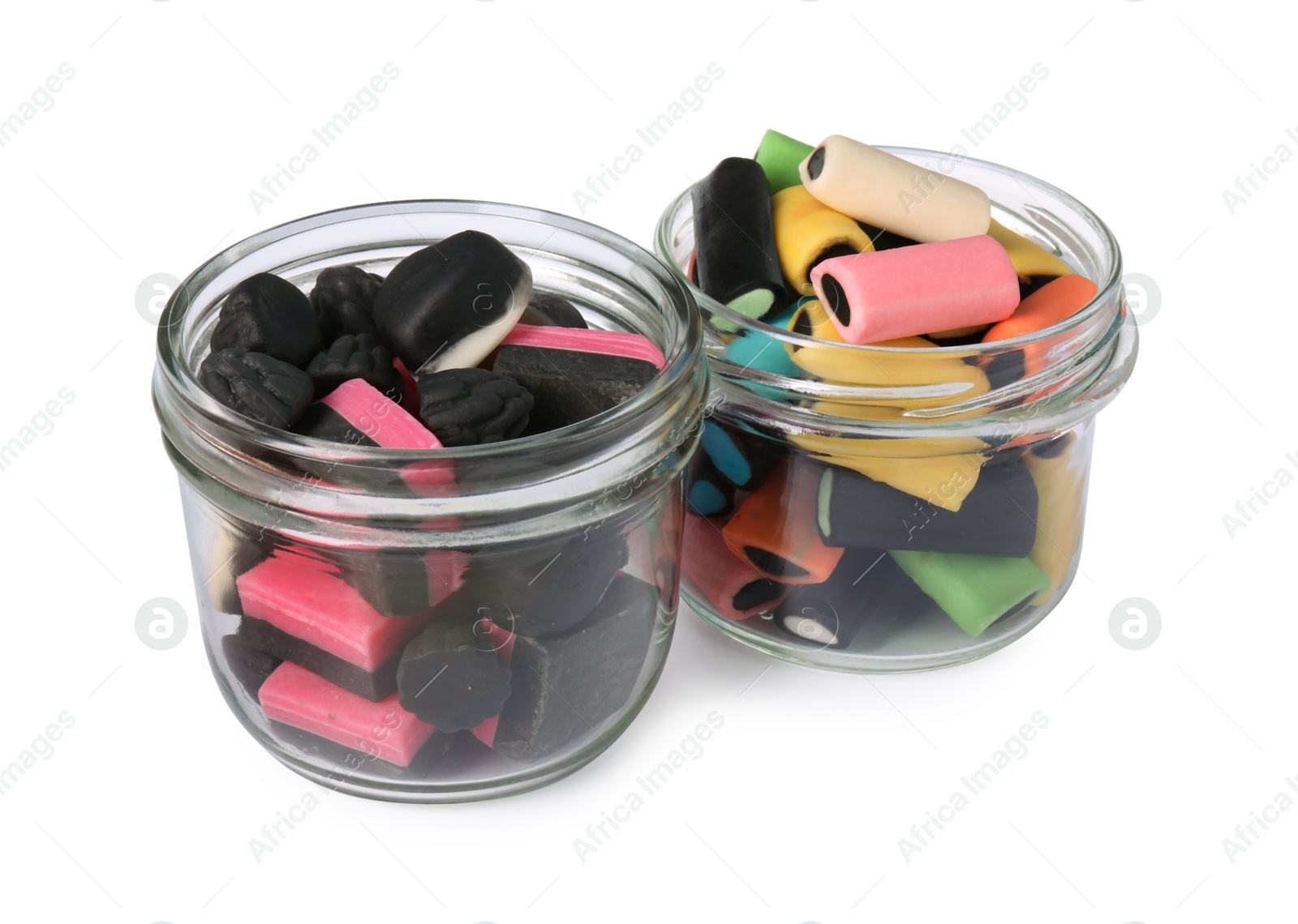 Photo of Glass jars of tasty liquorice candies isolated on white