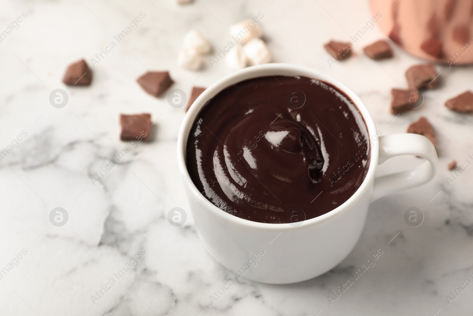 Photo of Cup of tasty chocolate drink on marble table