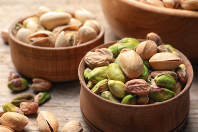 Composition with organic pistachio nuts on wooden table, closeup