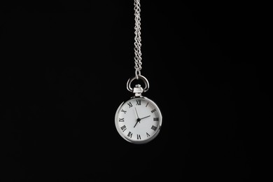 Beautiful vintage pocket watch with silver chain on black background. Hypnosis session