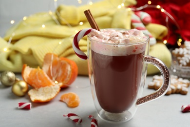 Photo of Composition with delicious marshmallow drink, festive items and yellow sweater on light table