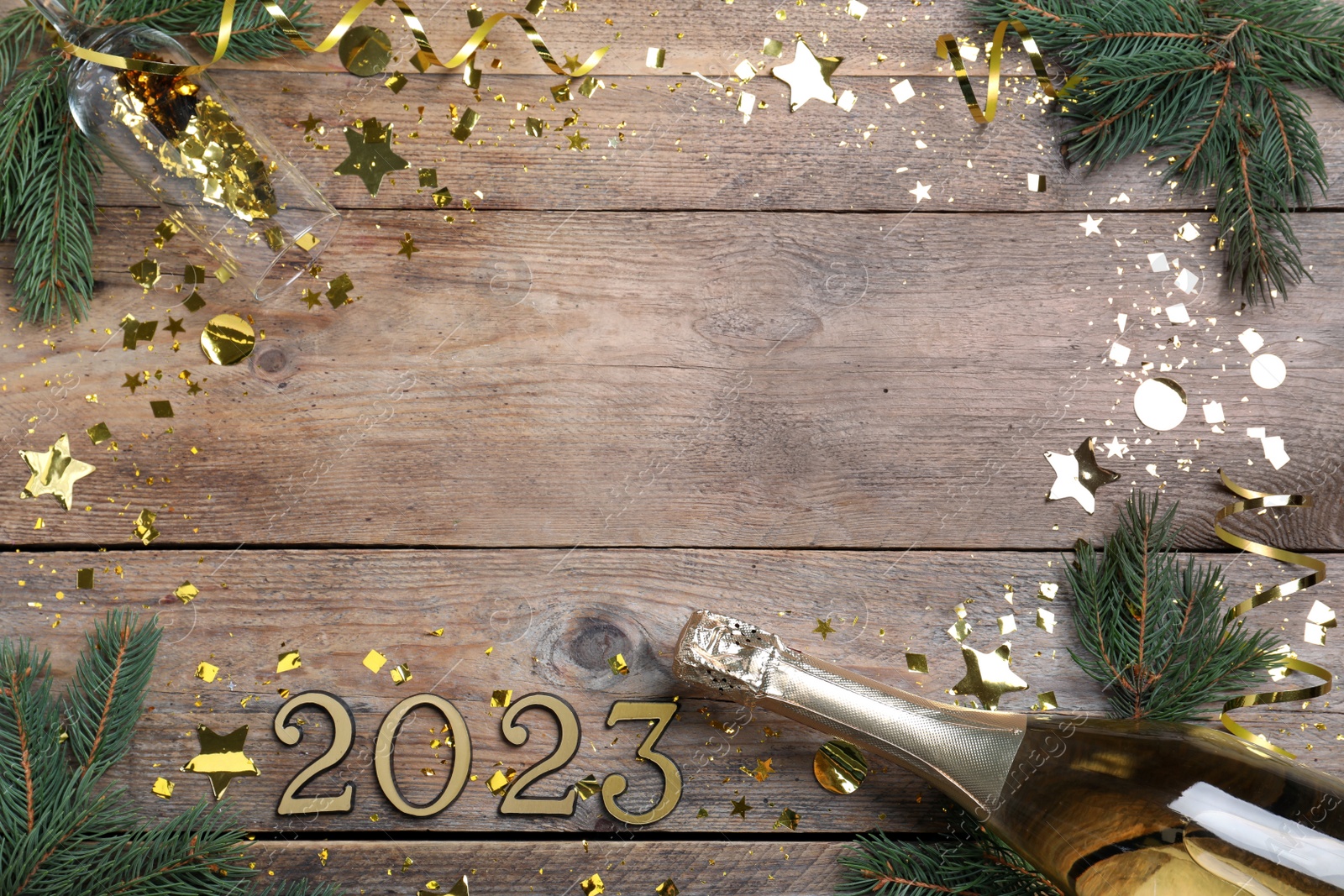 Photo of Happy New Year 2023! Flat lay composition with bottle of sparkling wine on wooden table, space for text