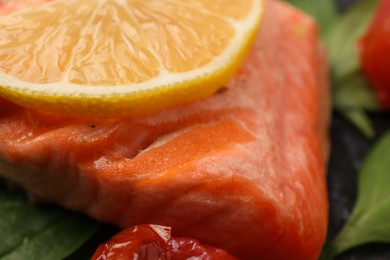 Photo of Tasty grilled salmon with lemon on plate, closeup