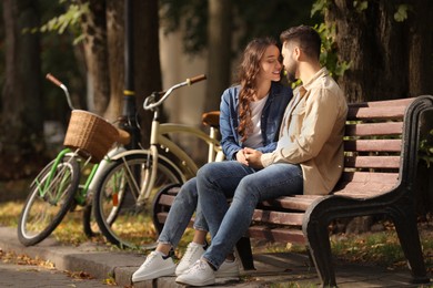 Photo of Beautiful couple spending time together in park, space for text
