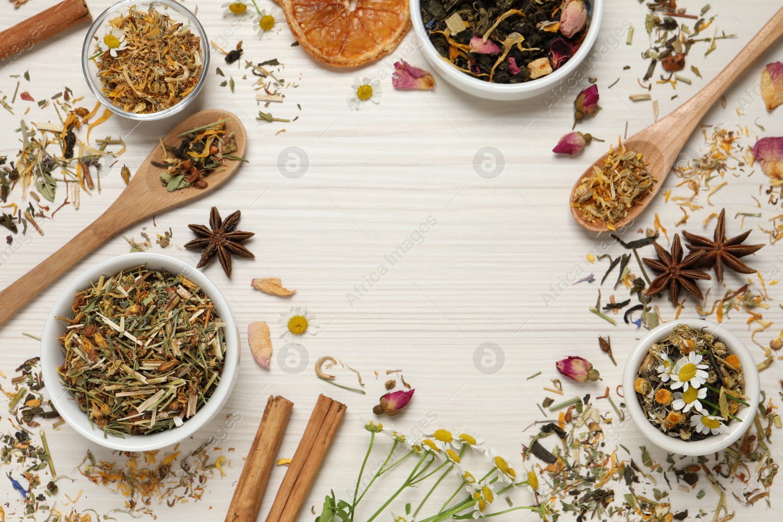 Photo of Frame of different dry teas on white wooden table, space for text