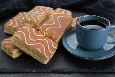 Tasty sponge cakes and hot drink on grey table, closeup