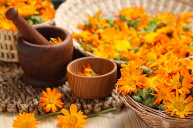 Many beautiful fresh calendula flowers on table