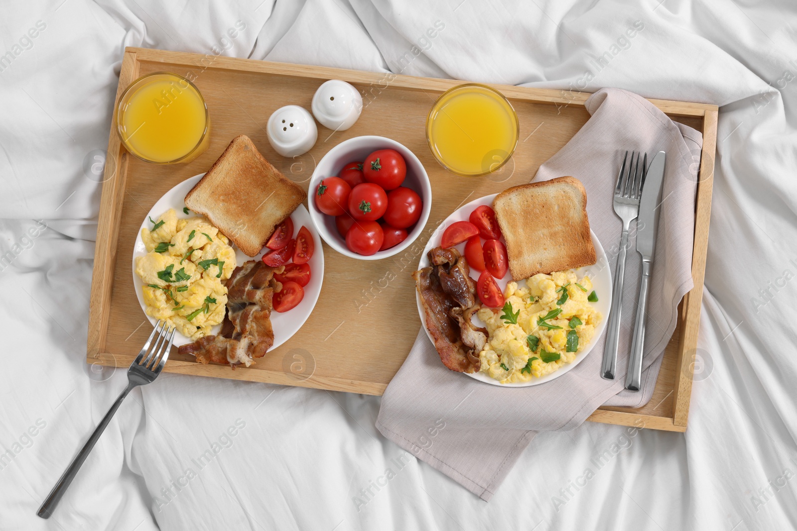 Good morning. Tray with tasty breakfast on bed, top view Photo of Good morning. Tray with tasty breakfast on bed, top view